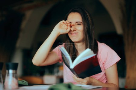 Mujer cansada leyendo un libro frotándose los ojos