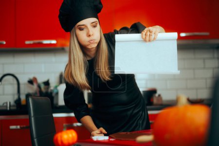 Téléchargez les photos : Femme perplexe utilisant du papier cuisson dans la cuisine - en image libre de droit
