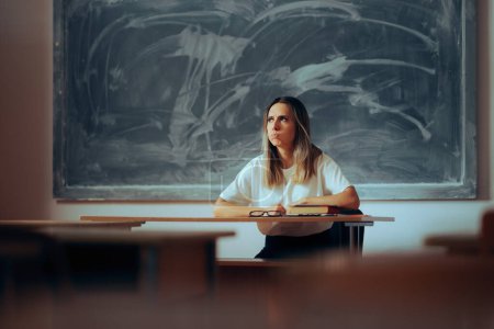 Photo for Stressed Teacher Sitting at the Desk Feeling Overwhelmed - Royalty Free Image