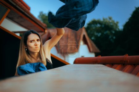 Photo for Furious Girlfriend Throwing Boyfriend Clothes Over the Balcony - Royalty Free Image