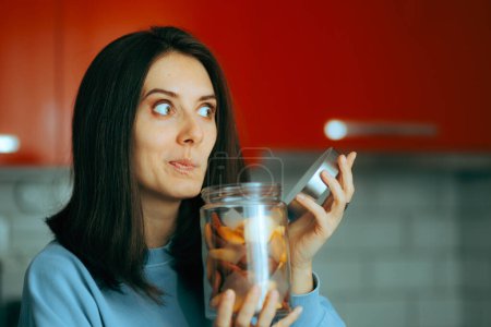 Photo for Funny Woman Sniffing a Bunch of Cookies in a Jar - Royalty Free Image