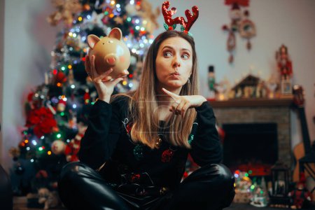 Photo for Funny Christmas Woman Pointing to a Piggy Bank - Royalty Free Image