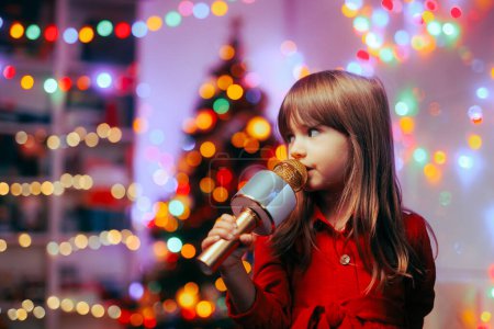 Glückliches Mädchen mit Mikrofon, das Weihnachtslieder singt 