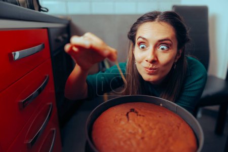 Téléchargez les photos : Femme cuisine à l'aide d'un cure-dent Vérification sur son gâteau cuit au four. - en image libre de droit