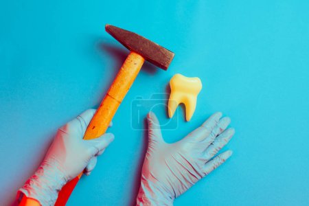Foto de Odontólogo poco profesional sosteniendo un martillo golpeando un diente - Imagen libre de derechos