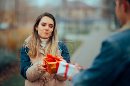 Téléchargez les photos : Petit ami et petite amie échangeant des cadeaux dans le parc - en image libre de droit