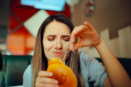 Photo for Woman Finding a Nasty Ingredient in a Fast-Food Sandwich - Royalty Free Image