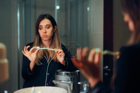 Frau checkt alte Zahnbürste, um sie wegzuwerfen