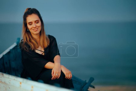 Schöne romantische Frau sitzt in einem Boot am Meer 