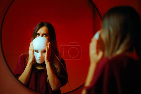 Foto de Mujer tímida escondiendo su cara detrás de una máscara de teatro - Imagen libre de derechos