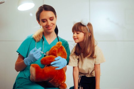 Téléchargez les photos : Infirmière pédiatrique sympathique faisant preuve de vaccination sur un ours en peluche - en image libre de droit