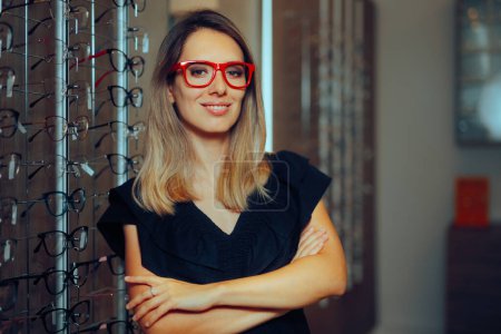 Mujer sonriente probándose marcos de gafas rojas en tienda óptica 