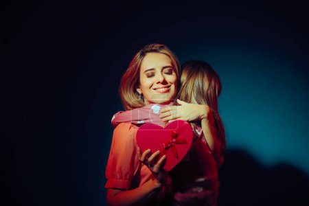 Photo for Mom Receiving a Heart Shaped Gift Hugging her Daughter - Royalty Free Image
