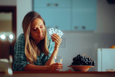 Woman Taking her Pills with a Glass of Water Before Sleep