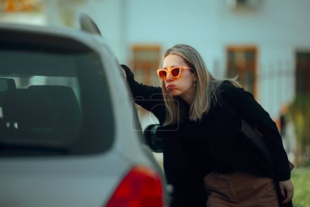 Mujer bloqueada fuera de su coche mirando dentro confundida