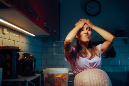 Mujer embarazada de pie en la cocina recordando algo