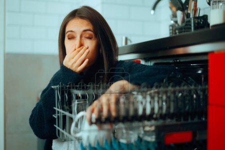 Téléchargez les photos : Femme ayant des problèmes avec une machine à laver la vaisselle malodorante - en image libre de droit