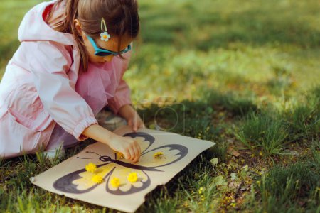 Téléchargez les photos : Enfant avec un bricolage Carton Printemps Activité avec des fleurs - en image libre de droit