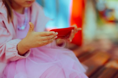 Photo for Child Using a Smartphone at the Playground instead of Playing - Royalty Free Image