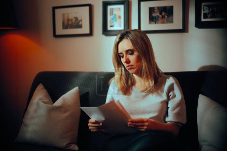 Ernsthafte Frau liest zu Hause auf dem Sofa einen Rechtsvertrag
