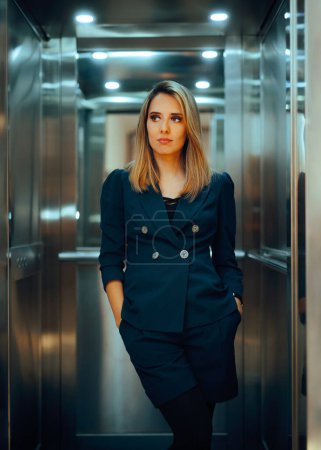 Geschäftsfrau steht mit den Händen in der Tasche im Fahrstuhl