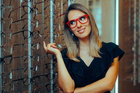 Glückliche Frau steht neben vielen Brillen im Optikgeschäft