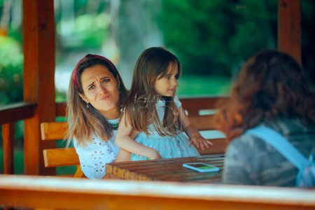 Madre tener una conversación mientras su hija exige atención