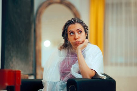 Mujer aburrida esperando en una peluquería con tinte en la cabeza