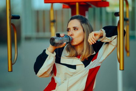 Sporty Woman Drinking Water After Exercising in a Public Park 