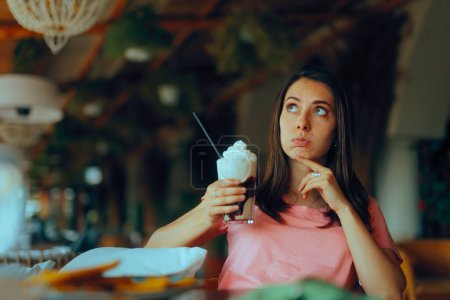 Mujer contando calorías sosteniendo un frappe con crema