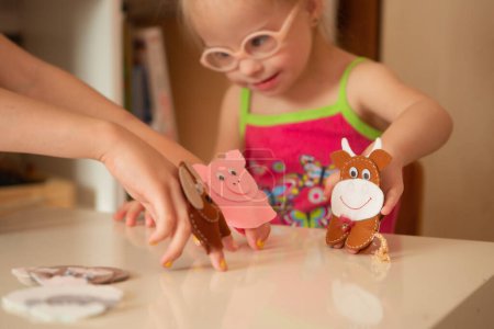Photo for A girl with Down syndrome develops fine motor skills. finger games - Royalty Free Image
