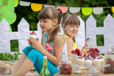 Photo for Two sisters on a summer sweet picnic. Tasty food. Birthday. Celebration. Holidays. Relaxation - Royalty Free Image