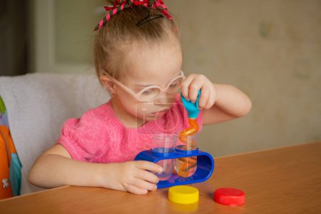 Photo for A girl with Downs syndrome learns to pour water Early development - Royalty Free Image