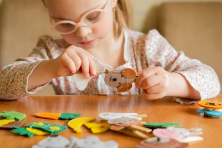 A girl with Down syndrome develops fine motor skills. Pin, dog