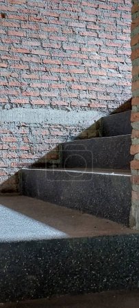 Téléchargez les photos : Lumière et ombre dans la cage d'escalier sur le ciment escaliers cas mur de briques - en image libre de droit