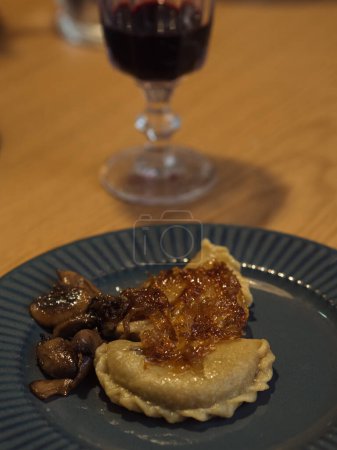 Foto de Vertical baja luz de cerca plano de un plato con albóndigas y una copa de vino tinto. - Imagen libre de derechos
