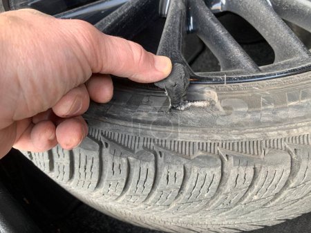 Foto de Neumático dañado. Un agujero en la rueda de un coche. Concepto: una rueda dañada necesita ser reemplazada. Región de Kiev, Irpen, 14 de marzo de 2023 - Imagen libre de derechos