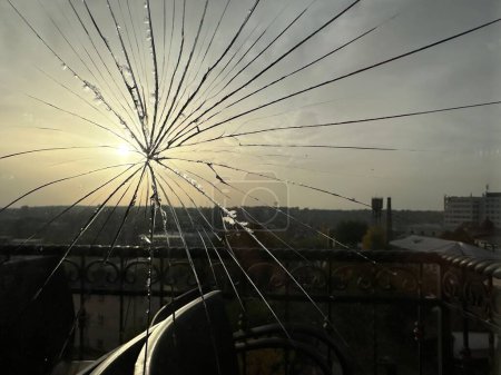 Foto de Vidrio agrietado en una ventana contra el fondo del sol. Grietas en una ventana de doble acristalamiento. Ventana rota en interiores. - Imagen libre de derechos