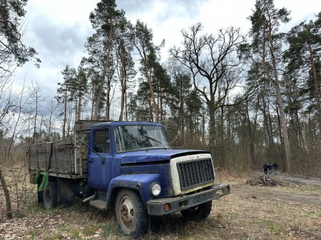 Vieux camion dans la forêt. Un camion avec un corps ouvert parmi les arbres. Camion en plein air cassé.