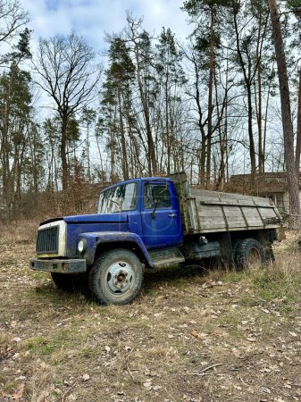 Un camión viejo en el bosque. Un camión con un cuerpo abierto entre los árboles. Camión al aire libre roto.