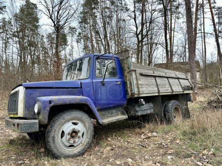 Téléchargez les photos : Vieux camion dans la forêt. Un camion avec un corps ouvert parmi les arbres. Camion en plein air cassé. - en image libre de droit