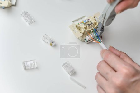 Foto de Installing a wall ethernet socket. Connecting wires to an socket. - Imagen libre de derechos