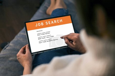 Photo for Woman browsing job opportunities online using tablet application for job search. unemployed job seeker looking for new vacancies on website page on tablet screen, hiring concept, rear view - Royalty Free Image
