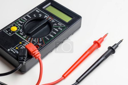 Photo for Digital multimeter with test leads on a white table. A multimeter is an electronic measuring instrument. - Royalty Free Image
