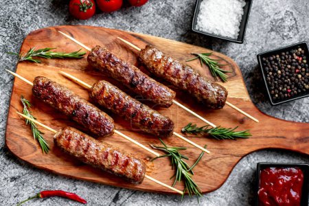 Photo for Grilled sausages with spices and herbs on a wooden board. - Royalty Free Image