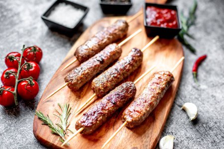 Photo for Grilled sausages with spices and herbs on a wooden board. - Royalty Free Image