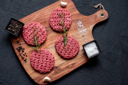 Foto de Carne picada cruda para hamburguesa con especias, concepto alimentario - Imagen libre de derechos