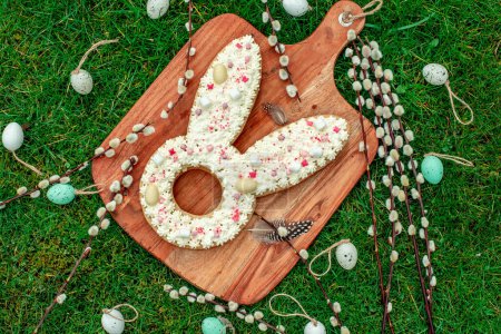 Foto de Pastel en forma de conejo de Pascua con huevos y flores - Imagen libre de derechos