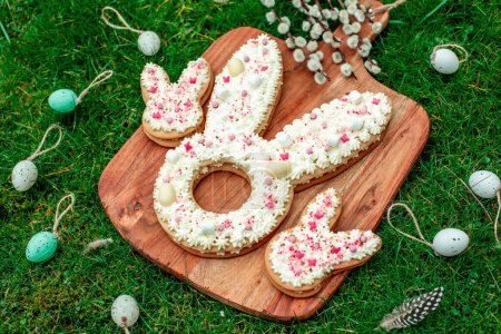 Téléchargez les photos : Biscuits en forme de lapin de Pâques à bord avec œufs et fleurs - en image libre de droit