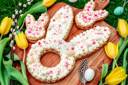 Téléchargez les photos : Biscuits en forme de lapin de Pâques aux œufs, fleurs de saule et tulipes - en image libre de droit